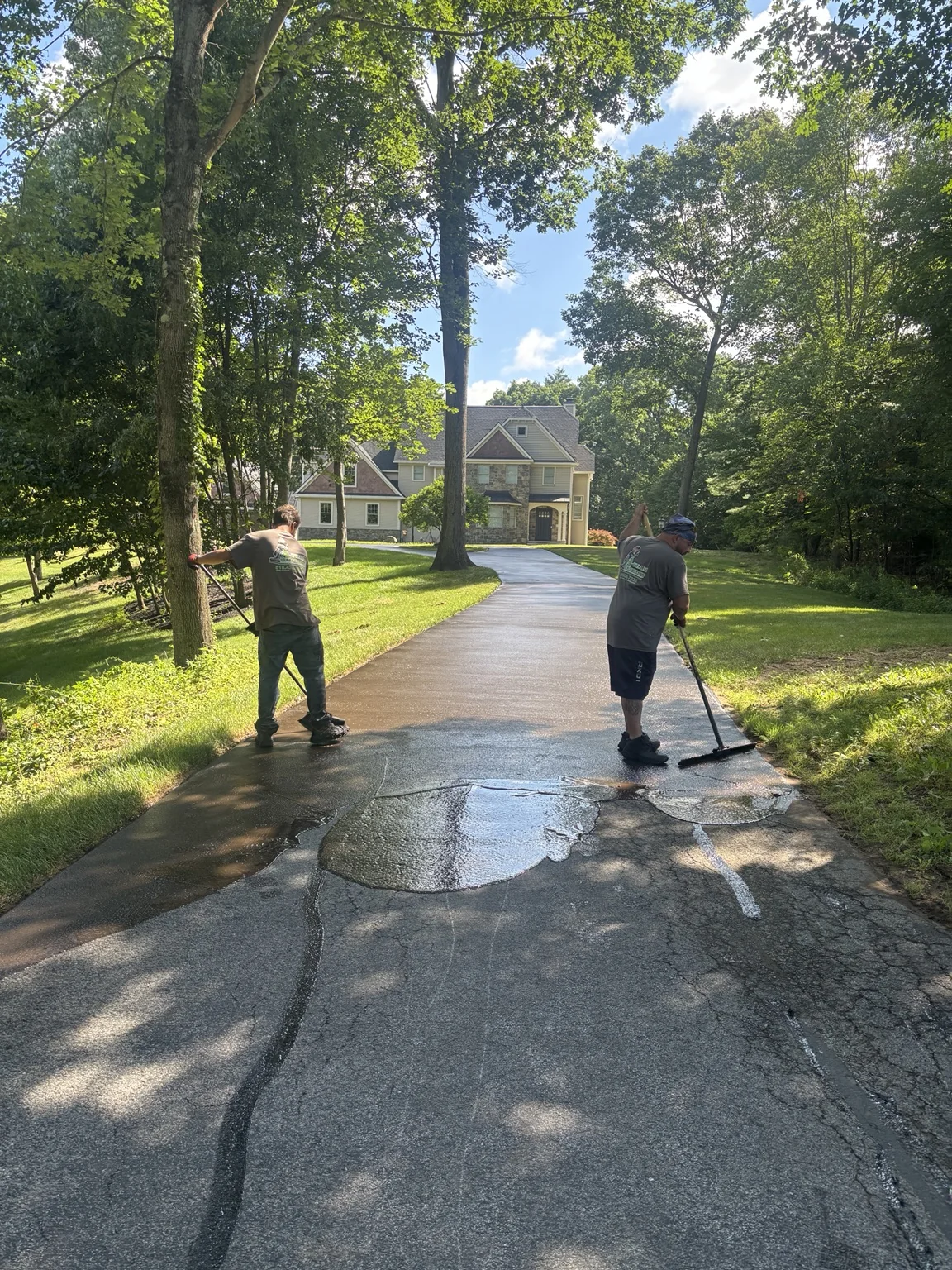 A-Team crew hand applying driveway sealer